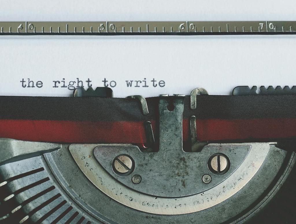 the words "the right to write" typewritten on a sheet of paper, in a vintage typewriter